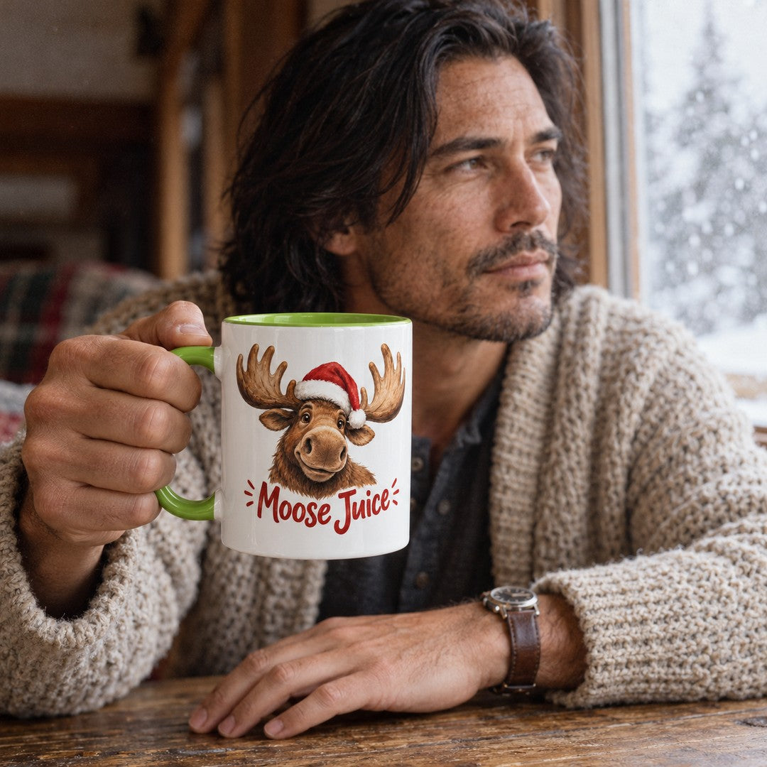 White ceramic mug with a light-green handle and a Santa-hat moose above the words Moose Juice