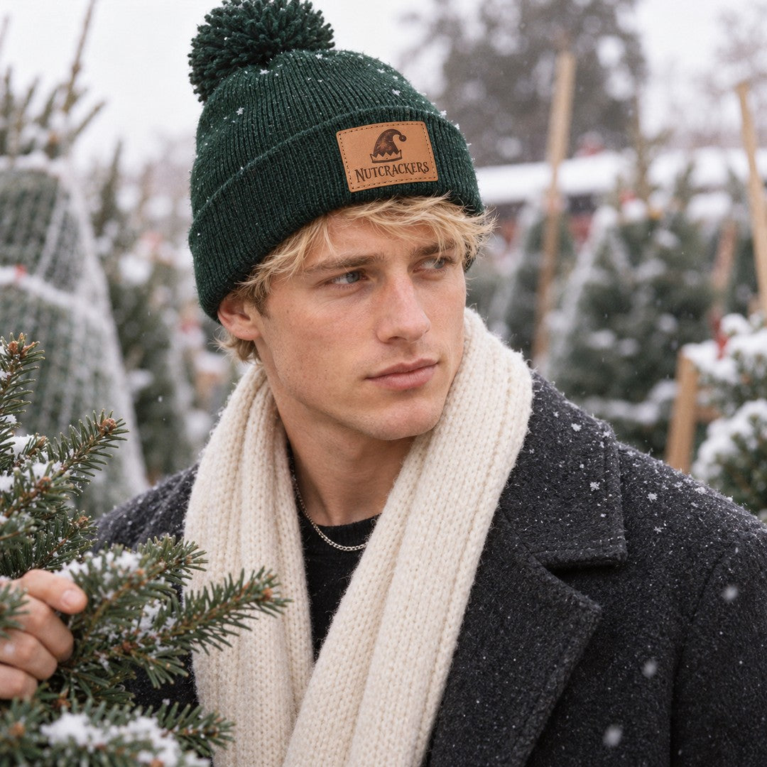 Man in a snowy Christmas tree lot wearing the Nutcrackers elf hat patch beanie