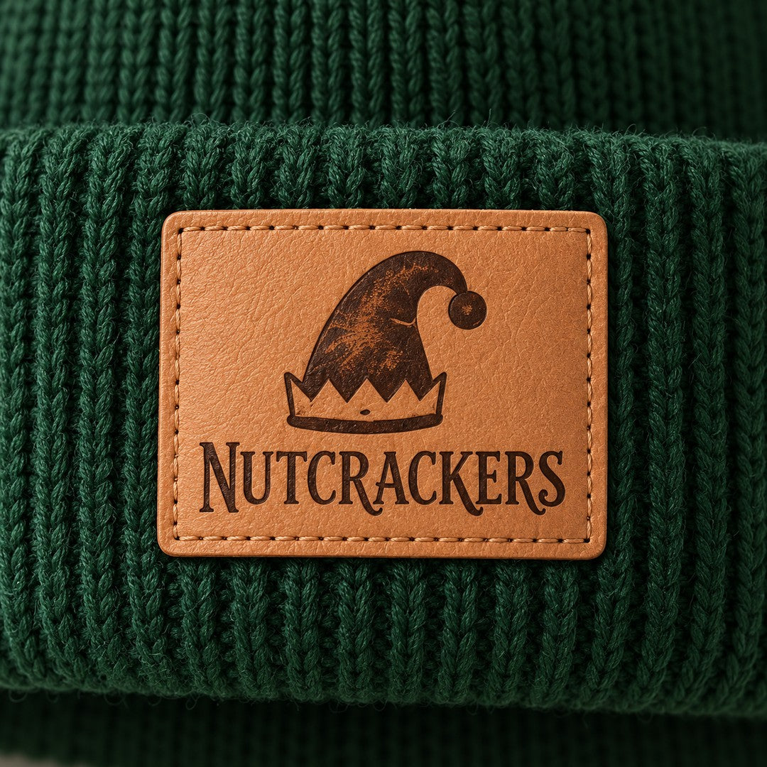 Close-up of the engraved leather patch: an elf hat above the word Nutcrackers