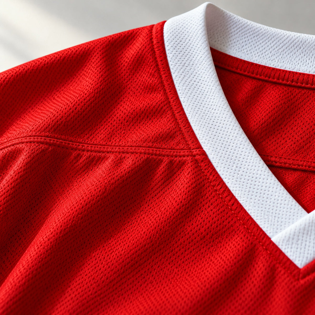 Close-up of the white V-neck collar band and mesh fabric