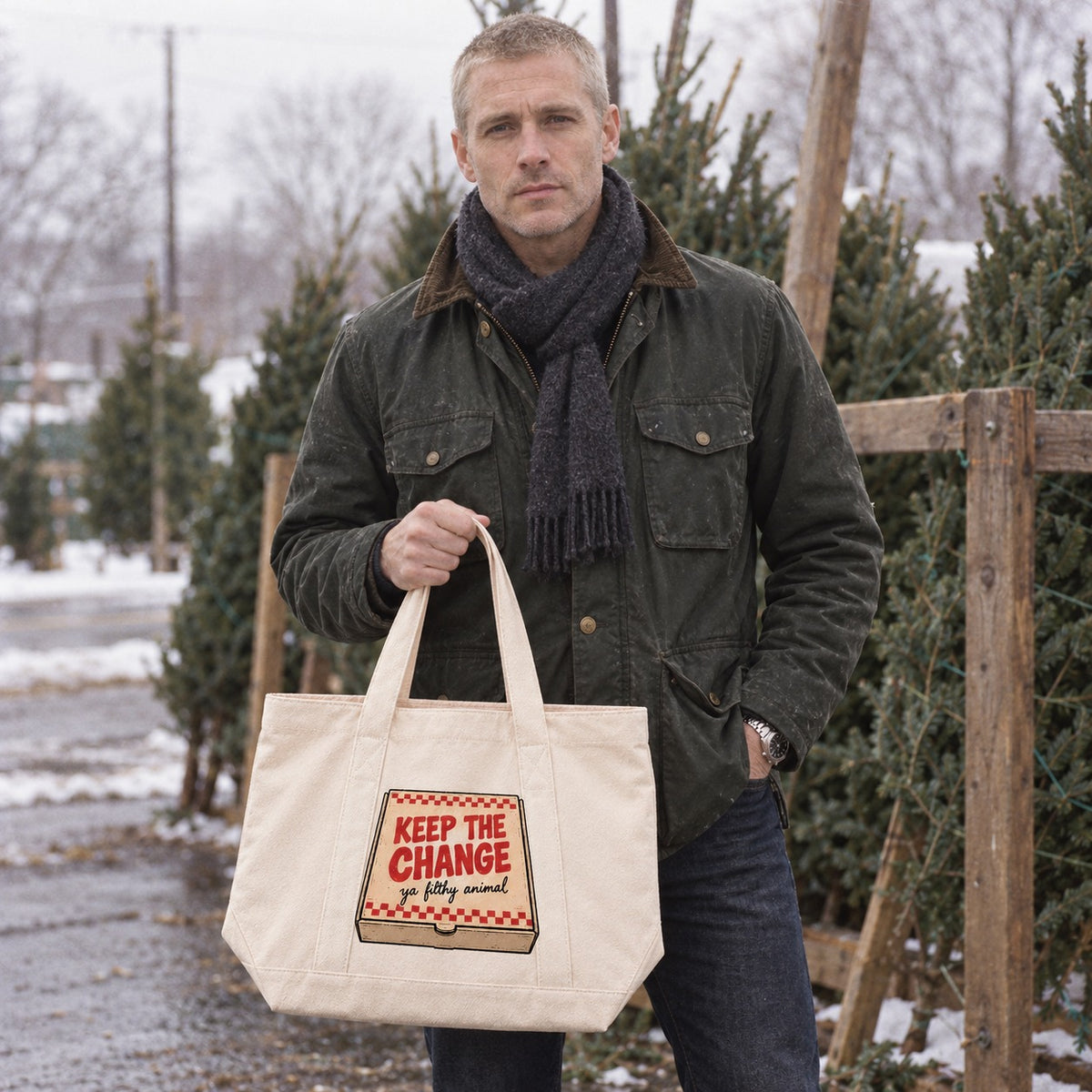 Man holding the Keep the Change pizza box tote bag at a Christmas tree lot